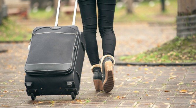 Closeup images of a woman taking a luggage in city.